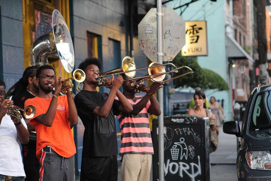 Four musicians are playing brass instruments on frenchmen street