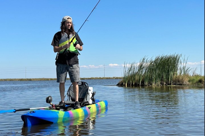 a man riding on the back of a boat in the water