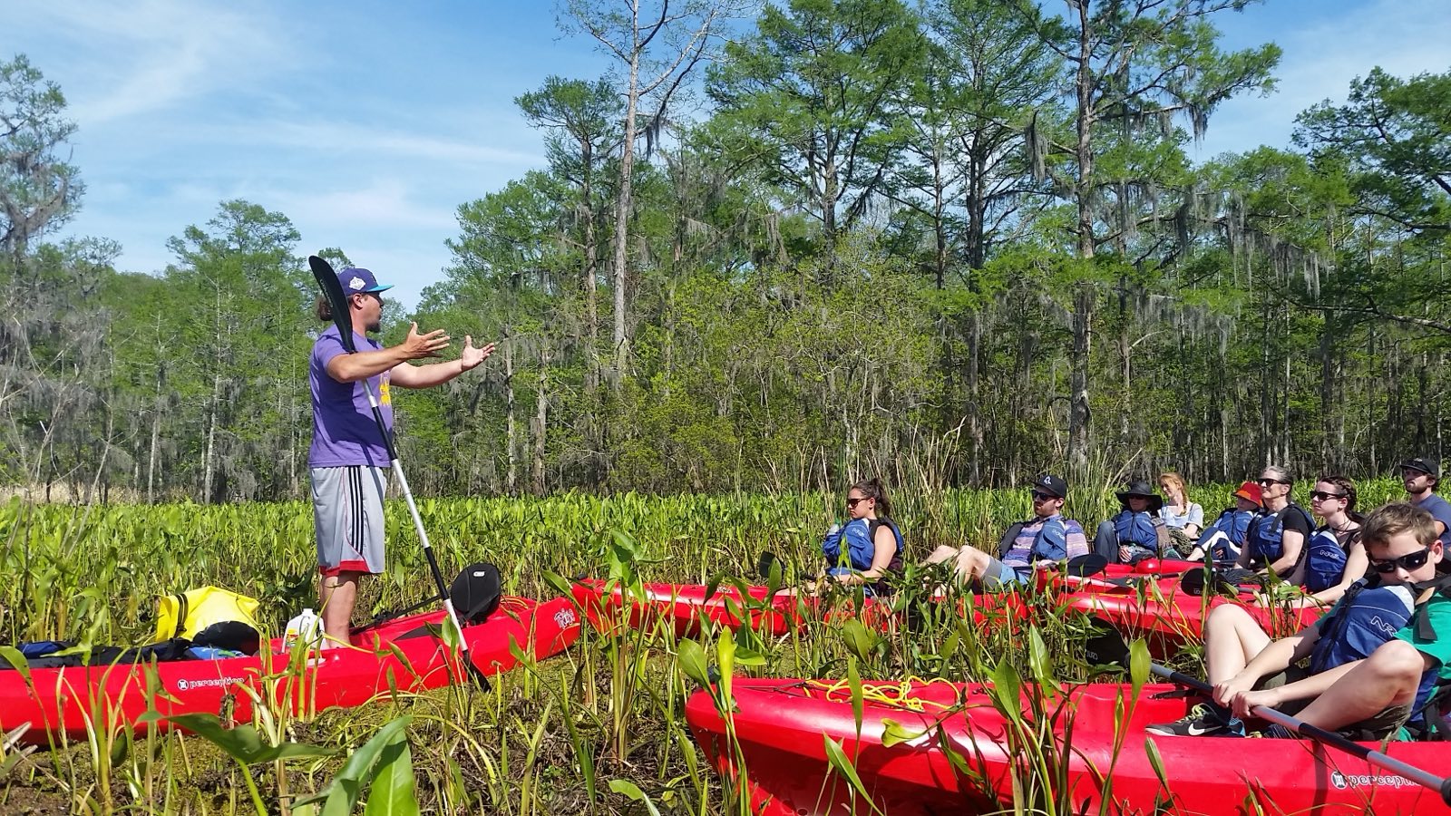 First-time kayakers paddling on a calm Manchac swamp tour with naturalist guides, no kayaking experience needed